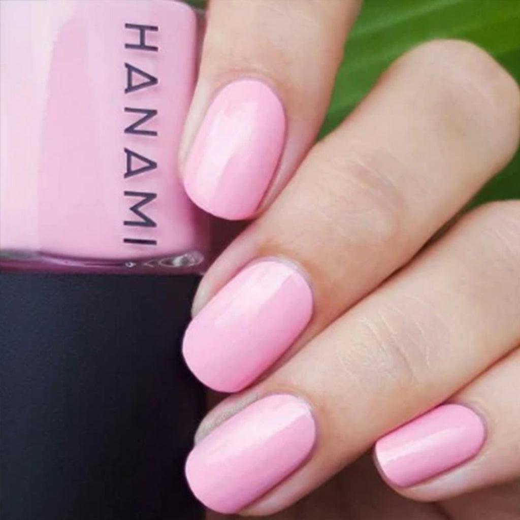 Pink nail polish on nails with a bottle of Hanami polish in the background