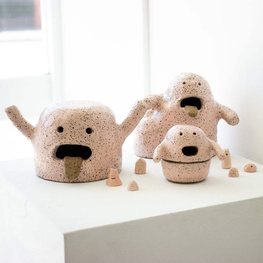 Picture of the collection of pink artwork stoneware clay figureines. 3 large figurines and 6 small figurines. 