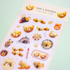A clear sticker sheet from valo's kitchen featuring cute cartoon bear illustrations in warm yellow, orange, and brown tones, photographed on a pale mint background.