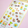A sheet of cute cartoon animal stickers laid diagonally on a pink background. The stickers feature various characters in brown, yellow, green, and beige tones, including bears, rabbits, cats, and small decorative motifs.
