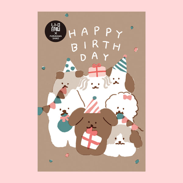 A birthday postcard featuring a illustration of several dogs wearing party hats and holding wrapped presents, with the words “HAPPY BIRTHDAY” in white at the top. The card has a warm taupe background and is centered on a light pink backdrop.