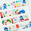 A sheet of decorative washi tape featuring colourful post office and delivery-themed illustrations, including a cat in a blue uniform, red post boxes, stamps, mailers, and a house on a white background.