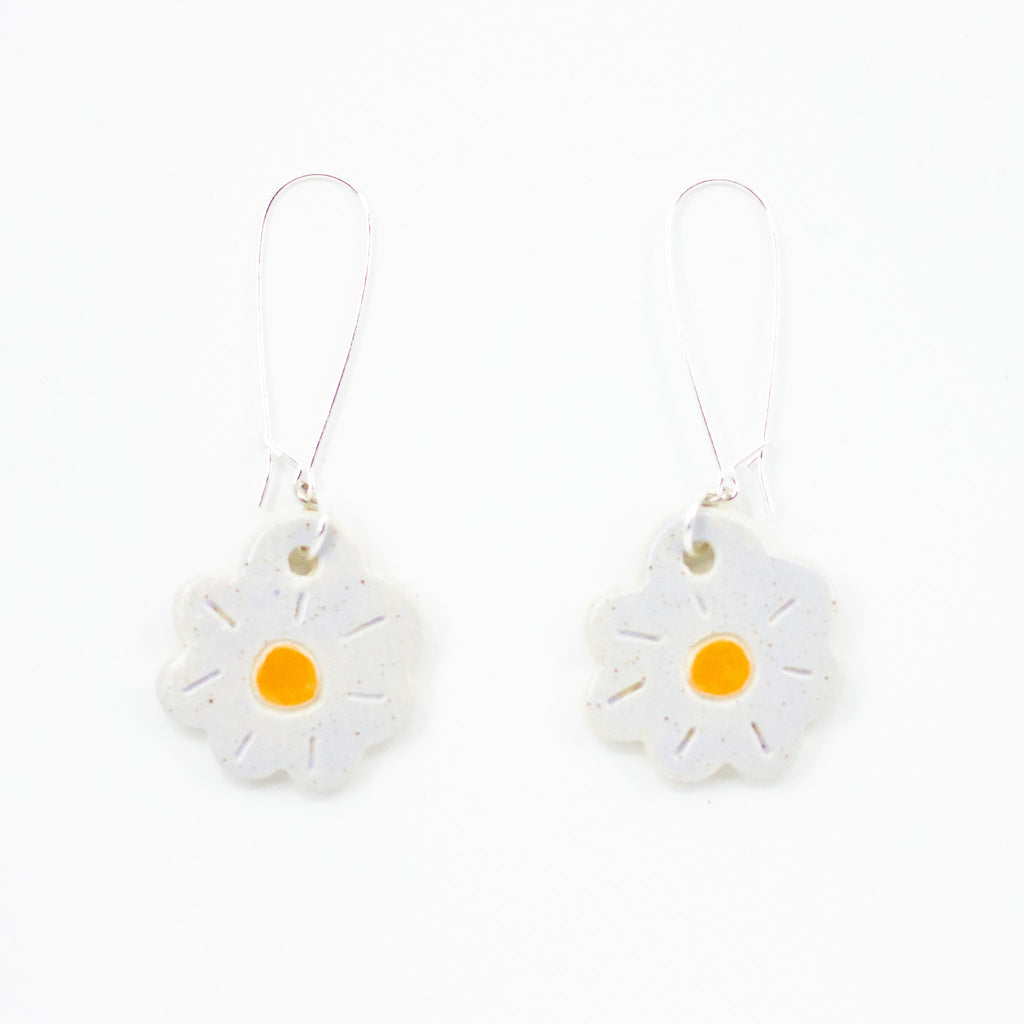 A picture of two Lilac coloured Posy ceramic earrings, with drop hooks in sterling silver. Ceramic beads are posy shaped, with lilac glaze and yellow centre.