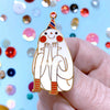 Hand holding a cartoonish ghost with a party hat against a colourful confetti background