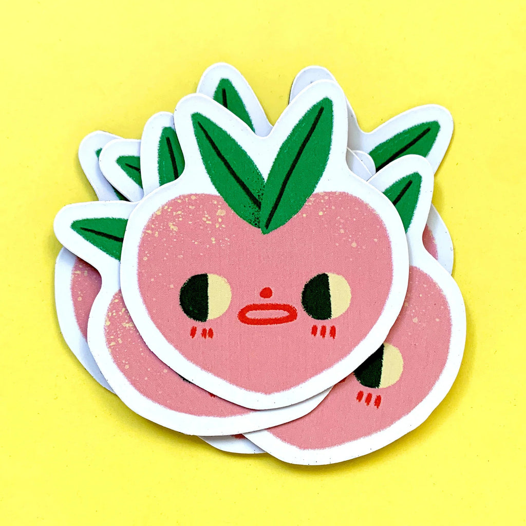 Stack of cute pink peach-shaped magnets with green leaves on a yellow background