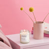 Candle on a nightstand with a pink background