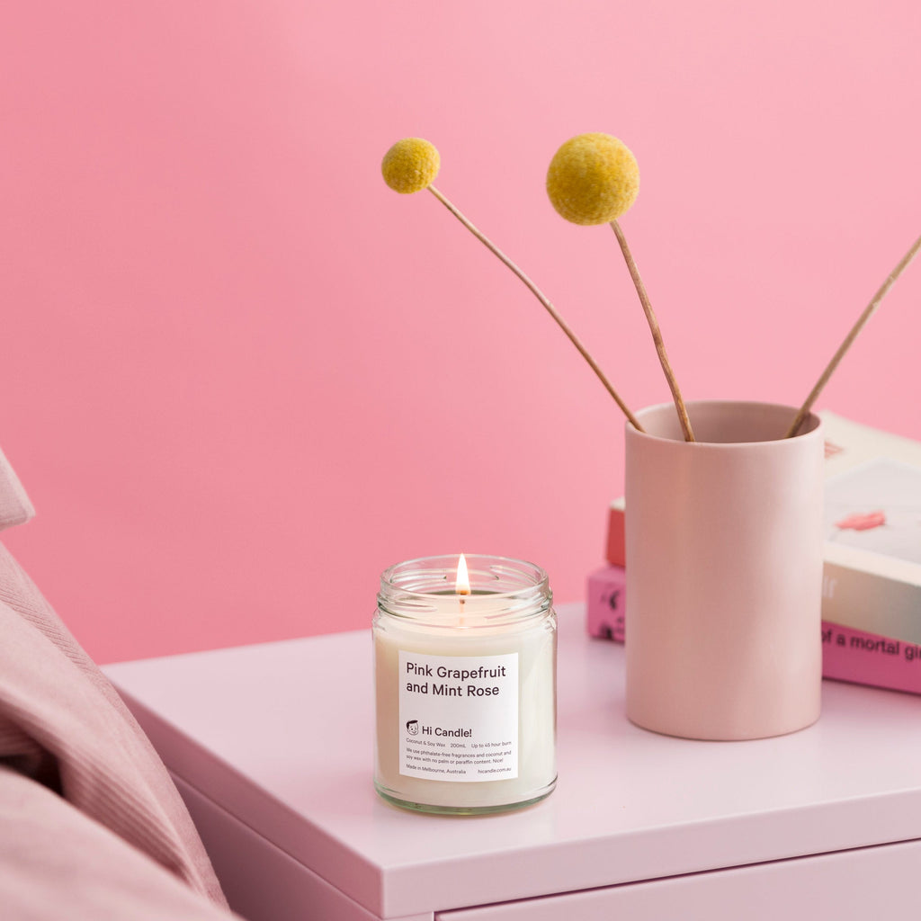 Candle on a nightstand with a pink background