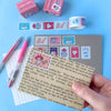 Card with decorative stamps and stationery items on a blue background