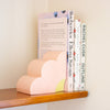 Quarter flower bookend in use holding up 3 books on a shelf. 