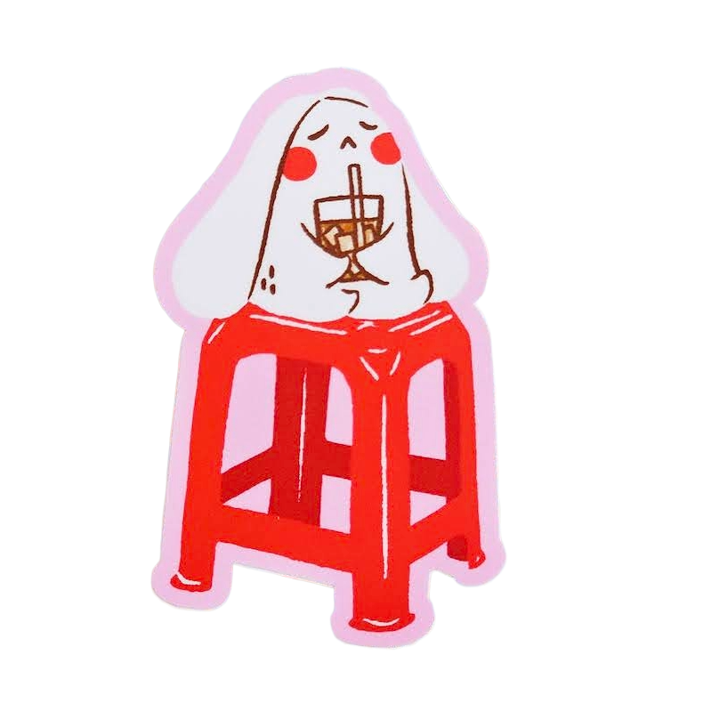 A die-cut sticker featuring a cartoon illustration of a white rabbit sitting on a red stool and holding a wine glass, set against a plain white background.