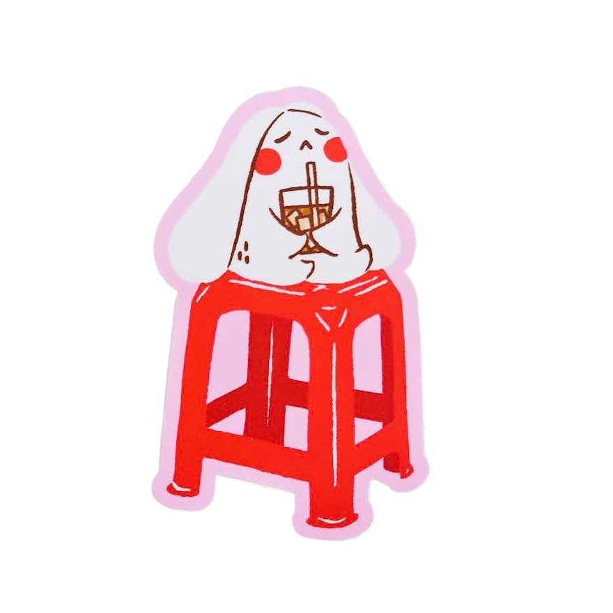 A die-cut sticker featuring a cartoon illustration of a white rabbit sitting on a red stool and holding a wine glass, set against a plain white background.