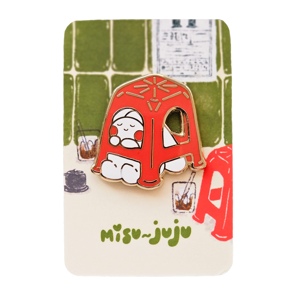 A Misu Juju enamel pin shaped like a red plastic stool with a cute cartoon character inside, mounted on its illustrated backing card.