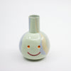 Ceramic vase with a smiley face on a white background