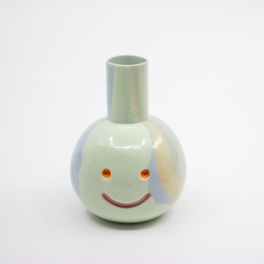 Ceramic vase with a smiley face on a white background