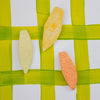 Three vegetable-shaped cookies on a green and white background