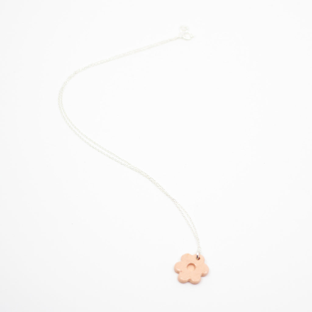 Necklace with a pink flower pendant on a white background