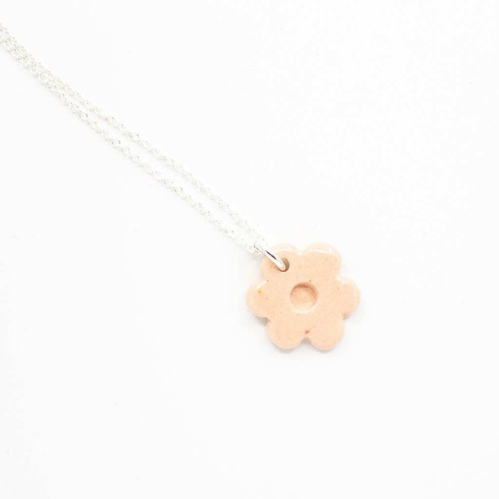 Necklace with a pink flower-shaped pendant on a white background