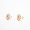 Pair of light pink flower-shaped earrings on a white background