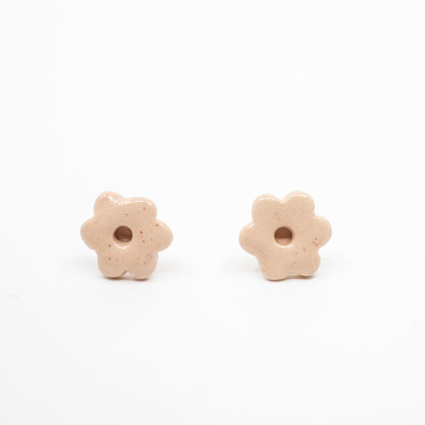 Two light pink flower-shaped beads on a white background