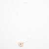 Sterling silver necklace featuring a light pink ceramic flower-shaped pendant with a red dot in the centre, displayed on a white background.