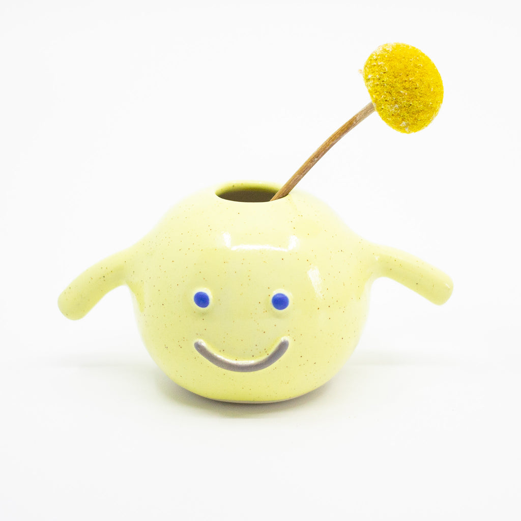 The sasha vase holding a flower, yellow