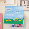 A square sticky note with the handwritten quote 'What's the next right thing to do!' on a blue sky background with a colourful flower field, displayed on a beige wall.