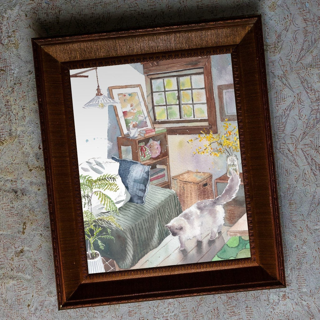 A framed watercolour painting of a cosy bedroom scene with a white cat walking across the floor, shown hanging on a textured light grey wall.