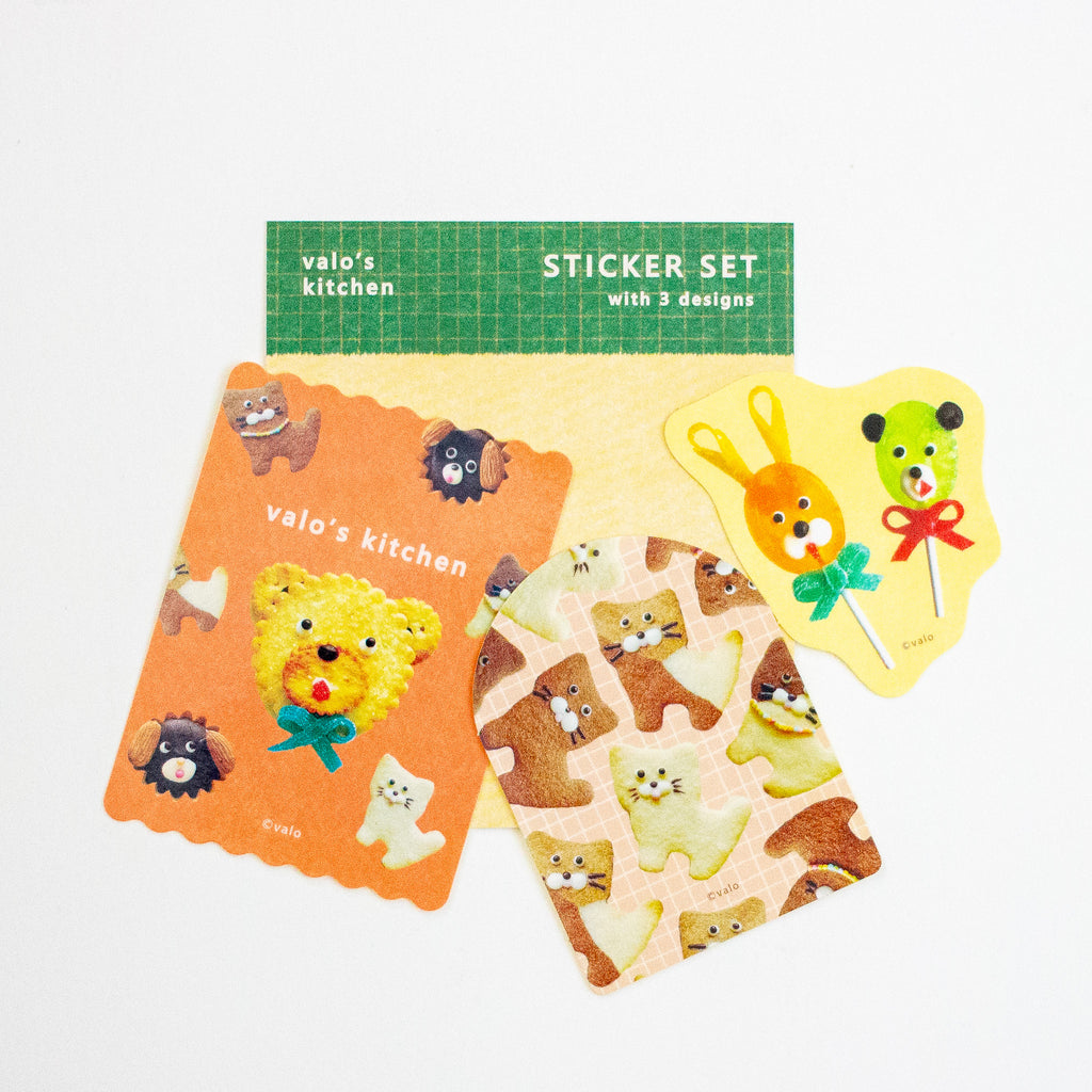 A cute sticker set from 'valo's kitchen' featuring three designs: a yellow bear lollipop, a green bear lollipop, and a sheet of cat-shaped stickers, displayed on a clean white background.