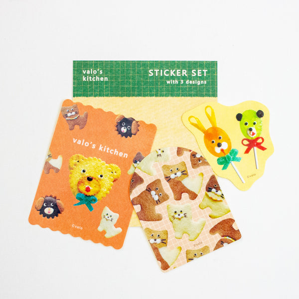 A cute sticker set from 'valo's kitchen' featuring three designs: a yellow bear lollipop, a green bear lollipop, and a sheet of cat-shaped stickers, displayed on a clean white background.
