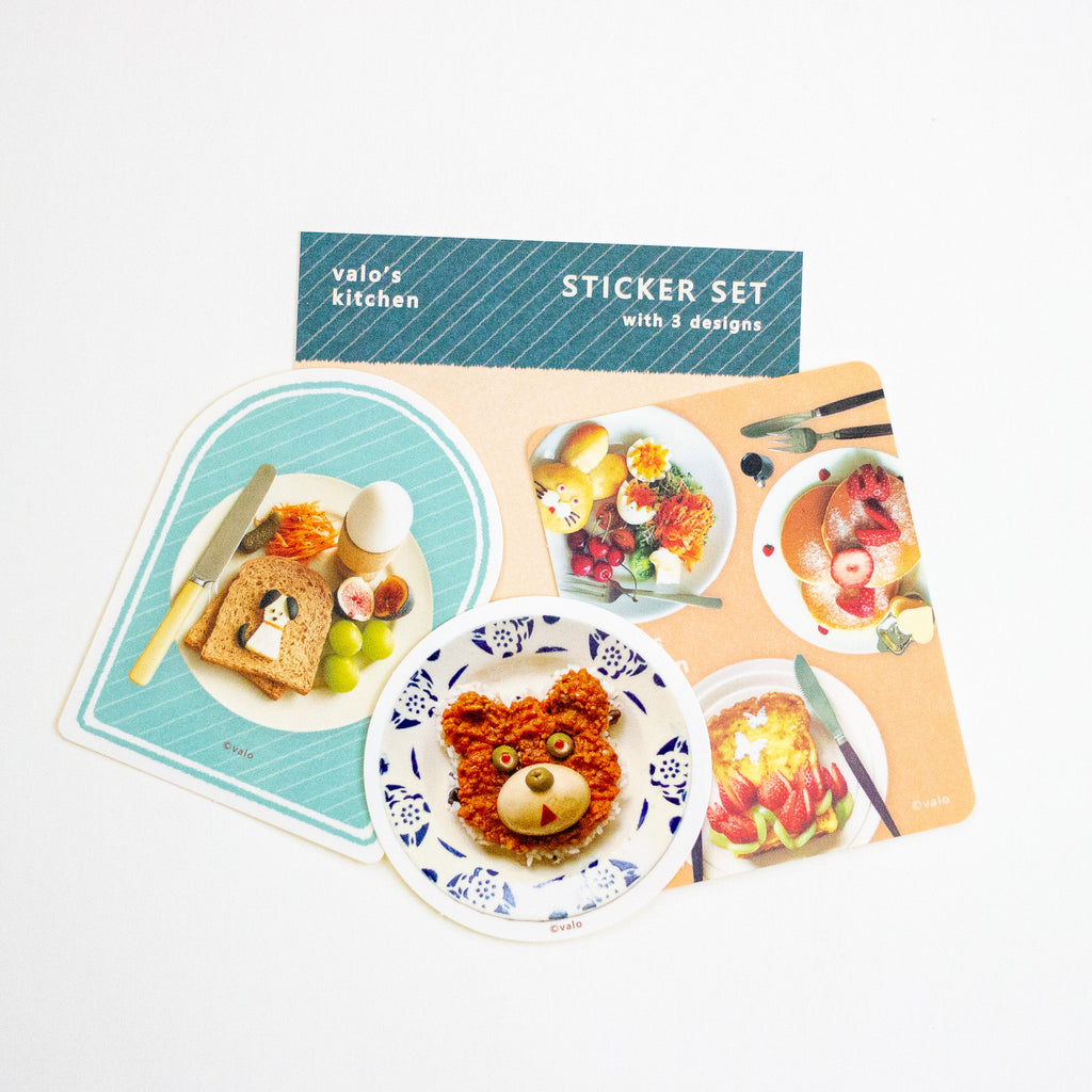 A sticker set from Valo's Kitchen featuring three breakfast-themed sticker designs: a dog toast, a bear-shaped dish, and a strawberry dessert, displayed on a white background with the packaging card behind them.