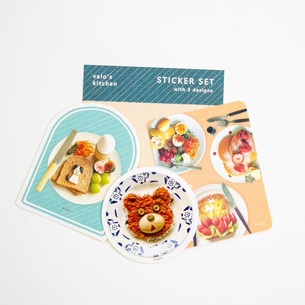 A sticker set from Valo's Kitchen featuring three breakfast-themed sticker designs: a dog toast, a bear-shaped dish, and a strawberry dessert, displayed on a white background with the packaging card behind them.