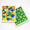 Top view of the shuh and spruce eco friendly dishcloth. Featuring 2 different bright and fun prints. 