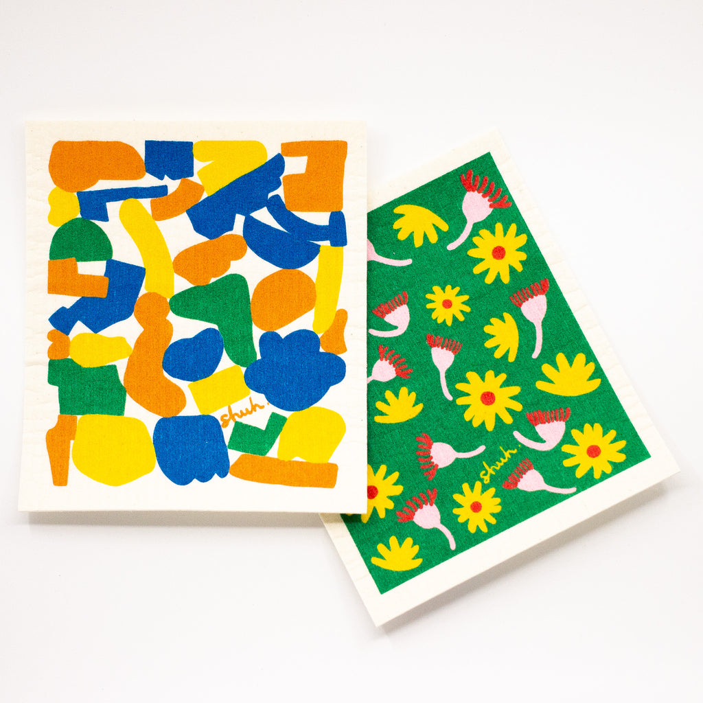 Top view of the shuh and spruce eco friendly dishcloth. Featuring 2 different bright and fun prints. 
