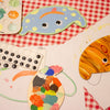 Painted wooden templates with googly eyes on a gingham table cloth