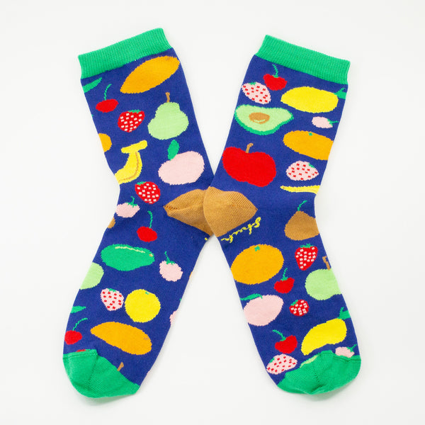 Bright blue socks with colourful fruit illustrations like cherries, bananas, and avocados. Green cuffs, tan heels and toes. Fun and cheerful design made in Australia.