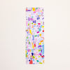 A tall, narrow bookmark featuring a colourful abstract watercolour splatter pattern on a white background, displayed vertically against a light beige backdrop.