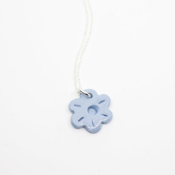 Blue flower-shaped pendant on a white background