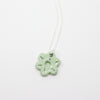 Necklace with a light green floral pendant on a white background