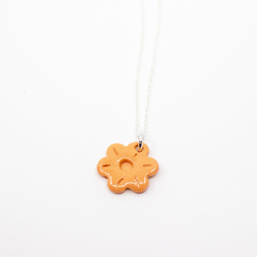 Orange flower-shaped pendant on a white background