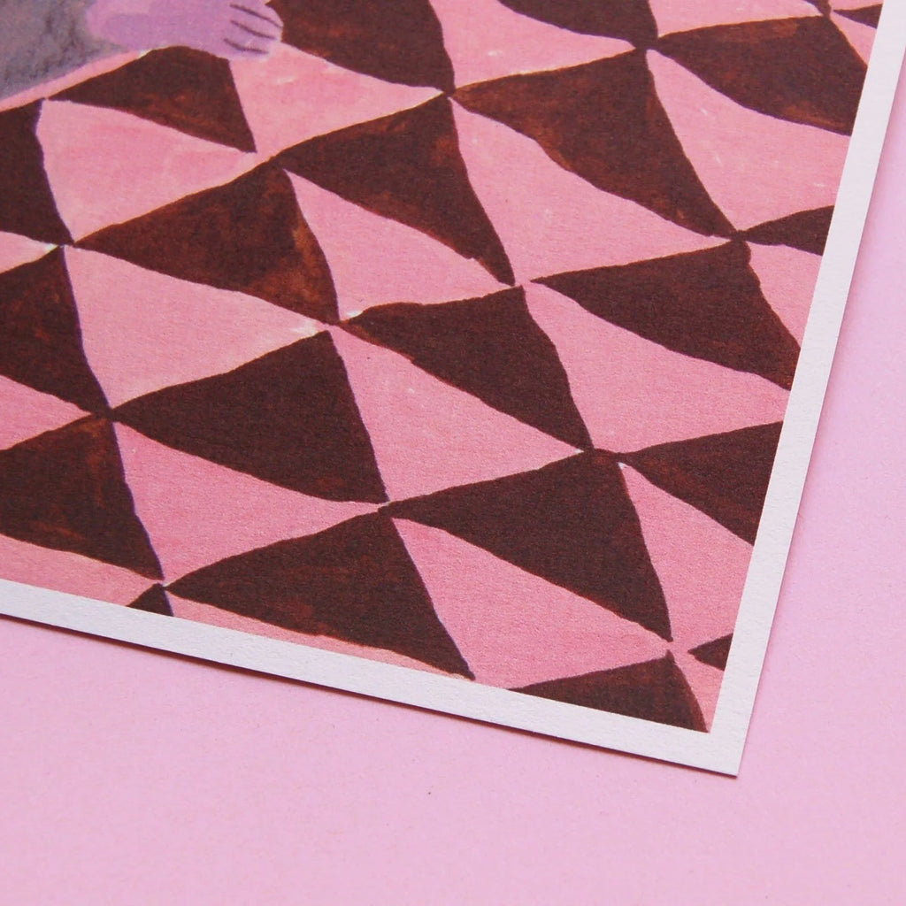 A photo showing a corner of a print with illustrated pink geometric pattern. 