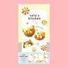 A small notepad with a cute cartoon food and animal illustration on the cover. 