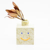 Front view of the sonia square vase with leaf. Natural colour with orange smile. 