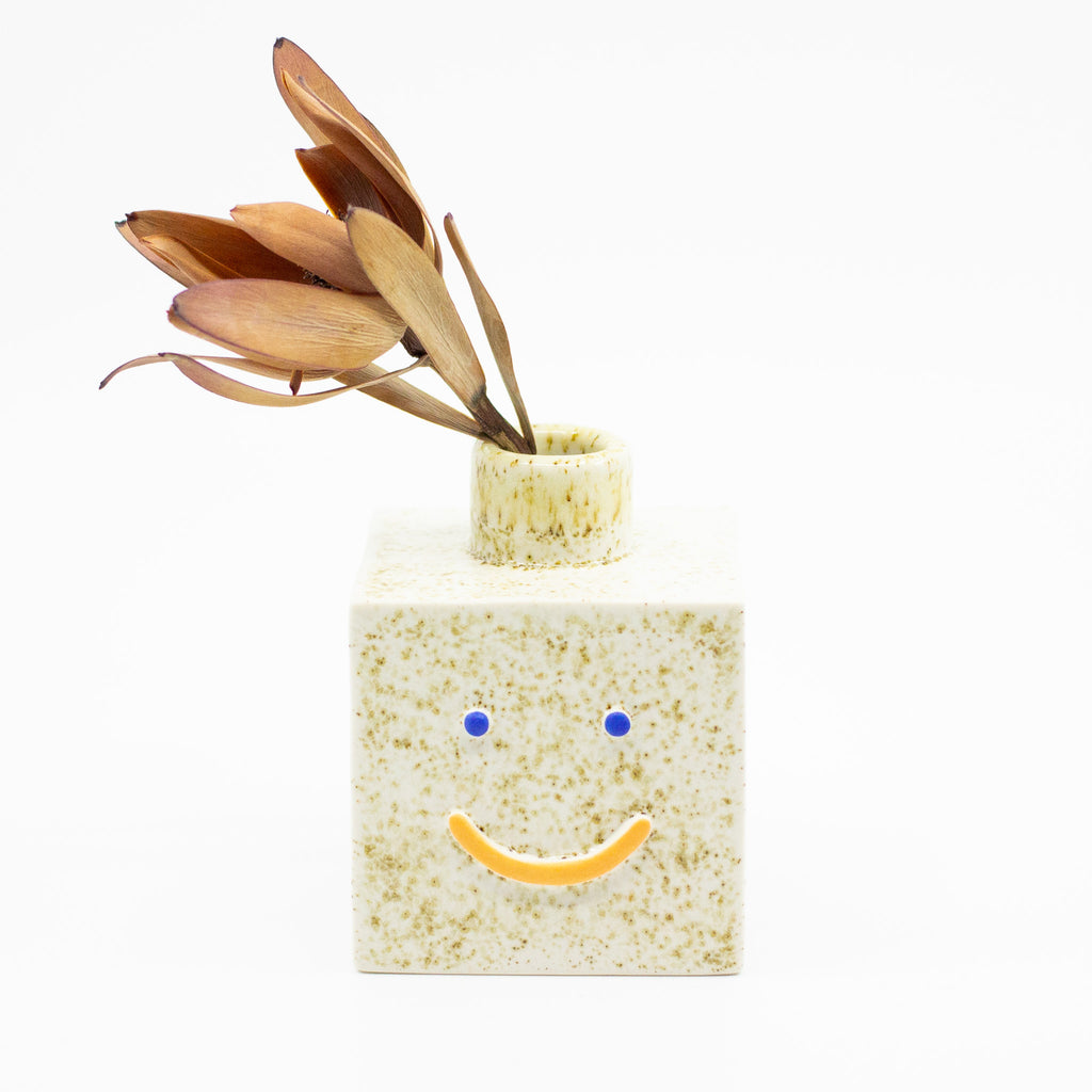 Front view of the sonia square vase with leaf. Natural colour with orange smile. 