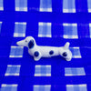 White dog figurine with blue spots on a blue checkered background