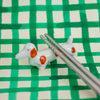 Dog-shaped ceramic chopstick rest on a green and beige checkered background