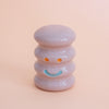 Small ceramic figurine with a smiley face on a peach background