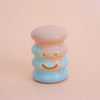 Small ceramic figurine with a smiley face on a peach background