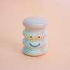Small ceramic figurine with a smiley face on a peach background