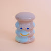 Small ceramic figurine with a smiley face on a peach background