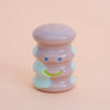 Small ceramic figurine with a smiley face on a peach background